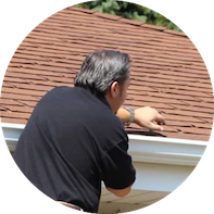 roof contractor inspecting damaged shingles